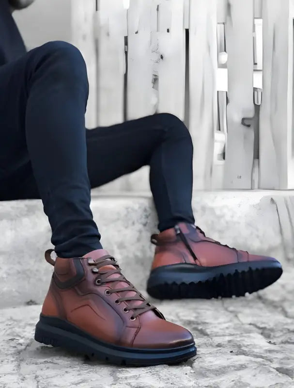Brown leather ankle boots with black chunky soles and dark laces.