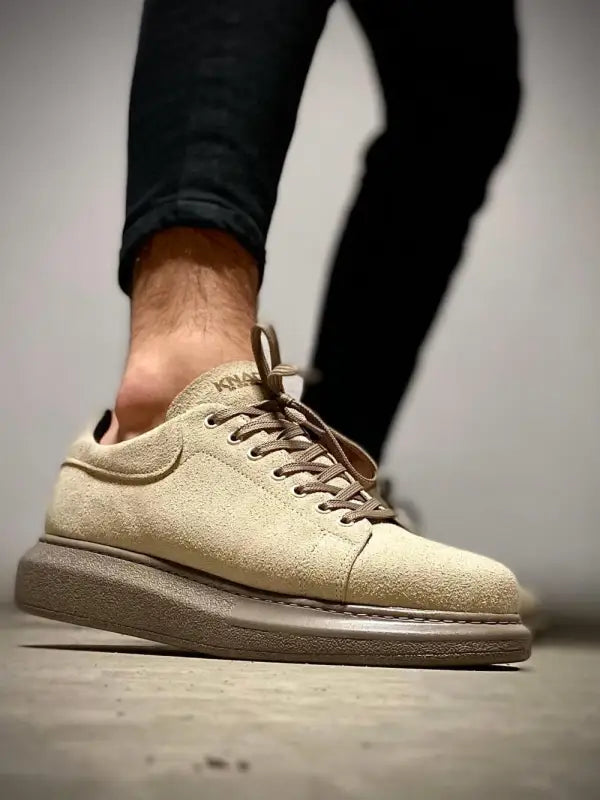 Beige suede sneaker with thick platform sole and brown laces.