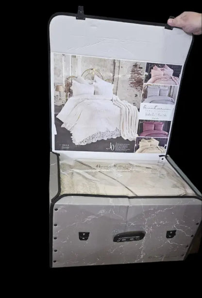 Vintage suitcase displaying a wedding dress advertisement and containing fabric or clothing inside.