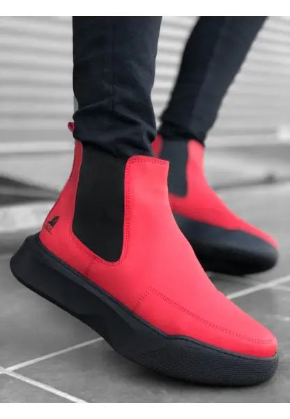 Red Chelsea boots with black elastic sides and chunky black soles.