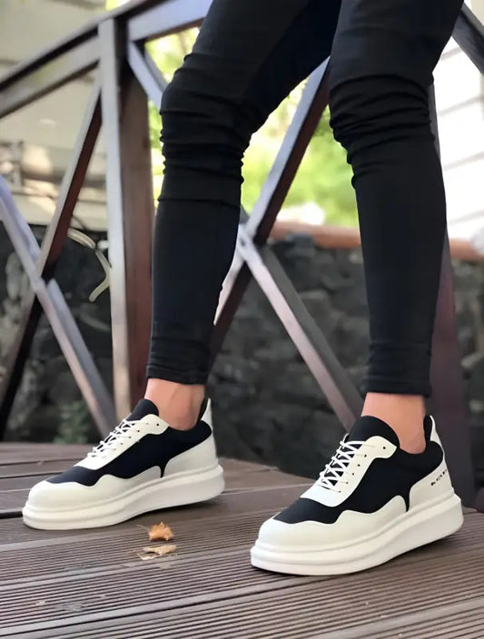 Black and white chunky platform sneakers with a suede and leather design.