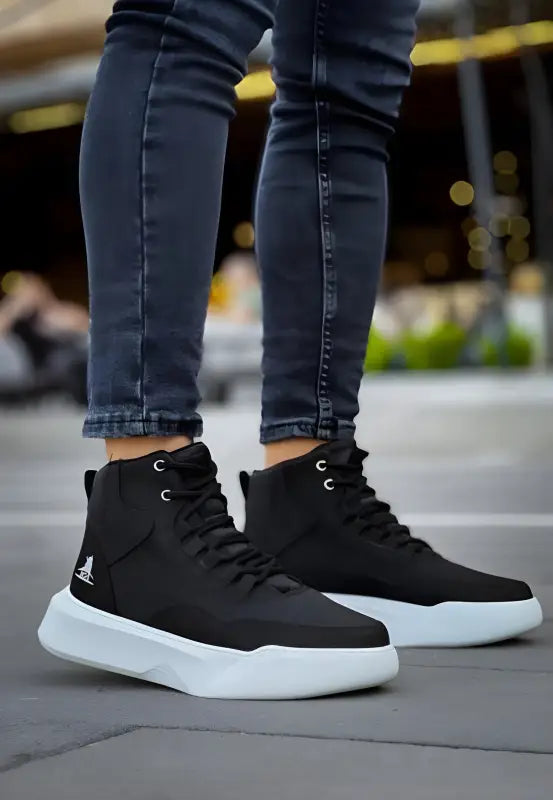 Black high-top sneakers with white soles and skinny jeans.