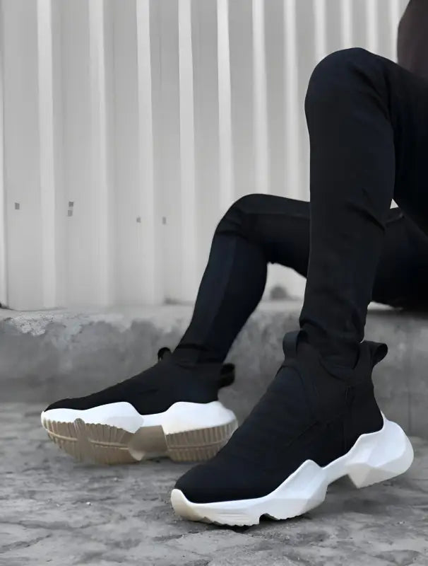 Black sock-style sneakers with white chunky soles.