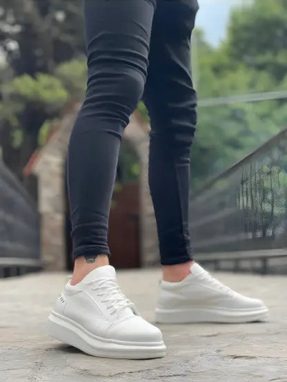 White sneakers with a chunky sole worn with black skinny jeans.