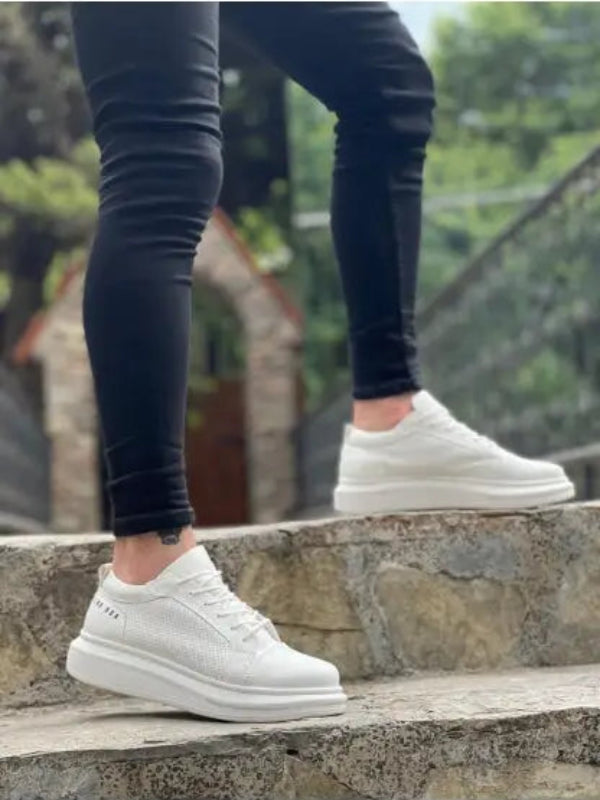 White leather sneakers with a chunky sole worn with black skinny jeans.