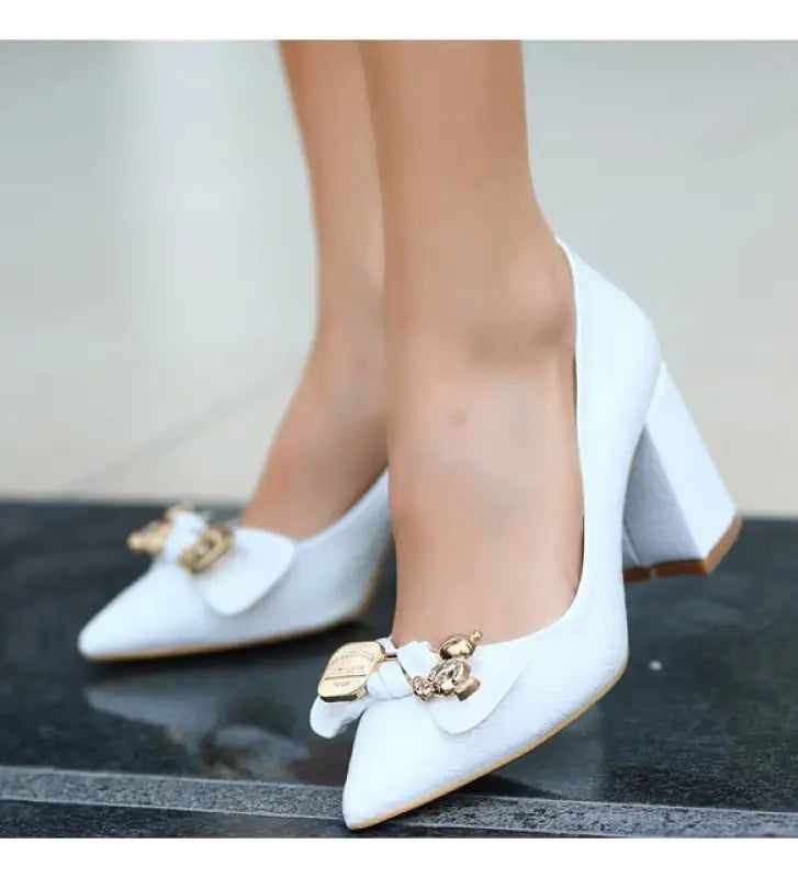 White high-heeled pumps with teddy bear embellishments.