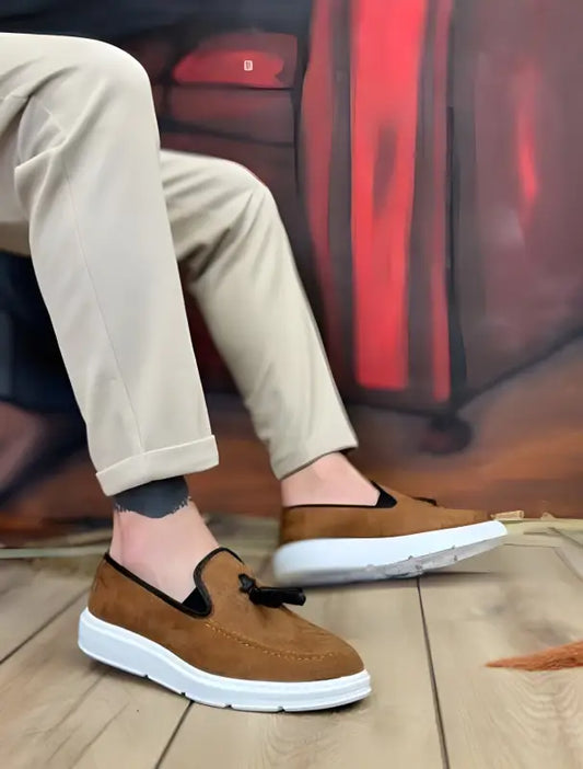 Brown suede slip-on sneakers with white soles and black trim.