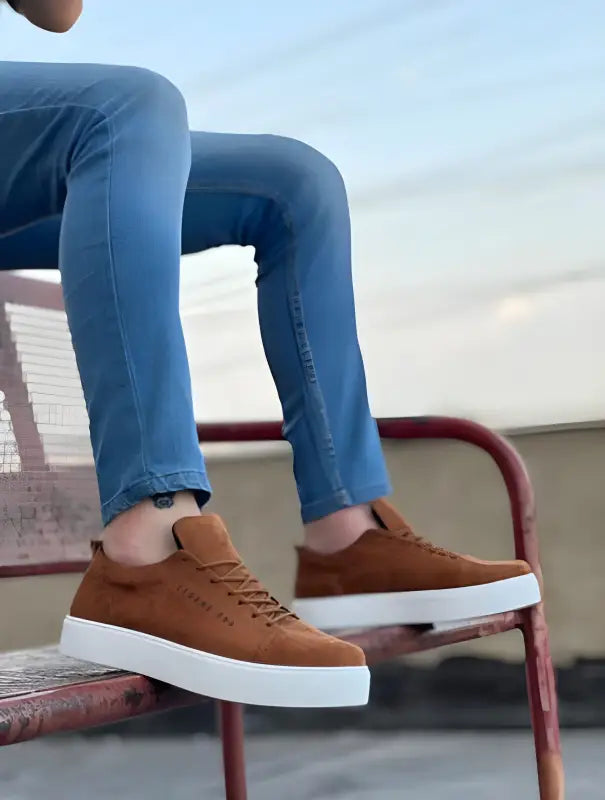 Brown suede sneakers with white soles and matching laces.