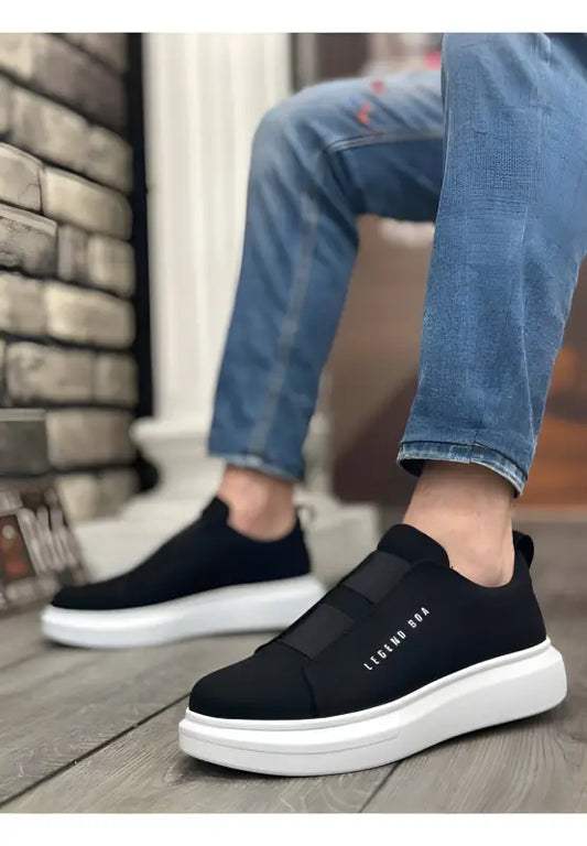 Black slip-on sneakers with white soles and minimal design.