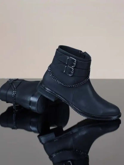 Black leather ankle boots with decorative buckle straps and stitching details.