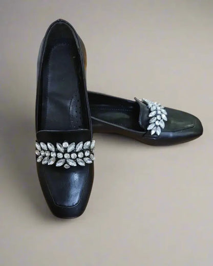 Black leather loafers decorated with crystal leaf embellishments across the vamp.