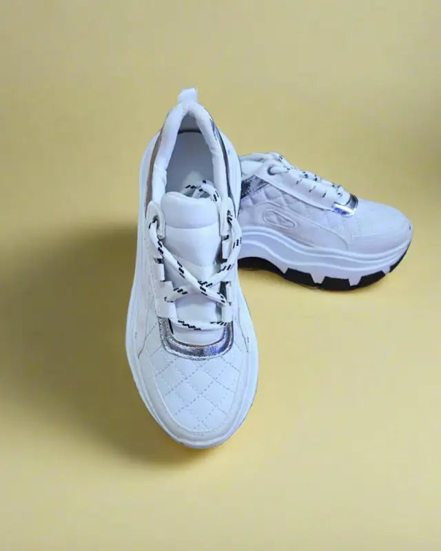 White chunky athletic sneakers with quilted texture and thick soles.