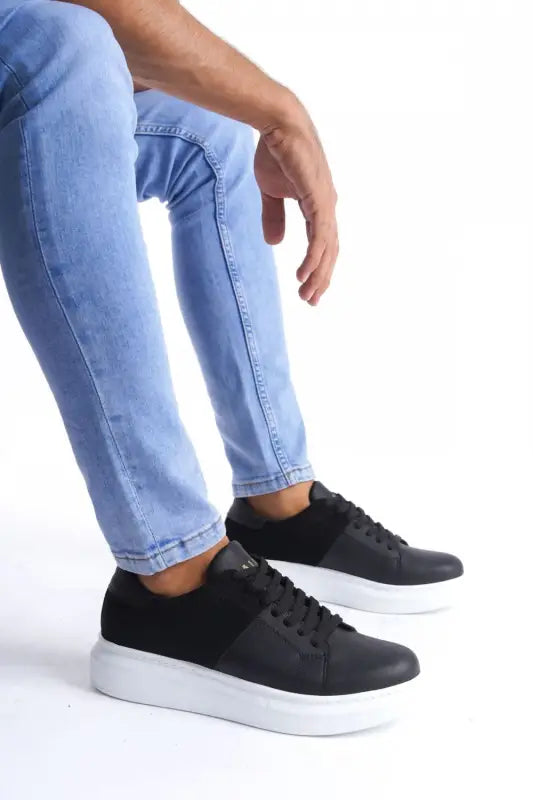 Black leather sneakers with white platform soles and laces.