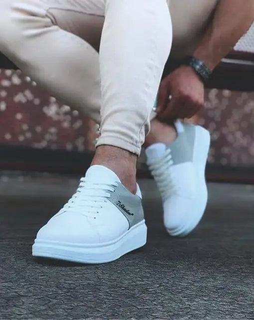 White leather sneakers with a minimalist design and platform sole.