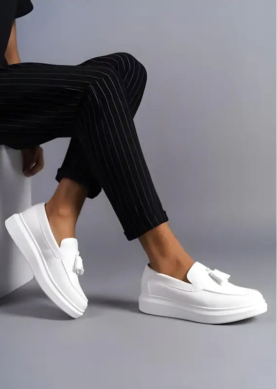 White platform slip-on loafers with decorative bow detail.