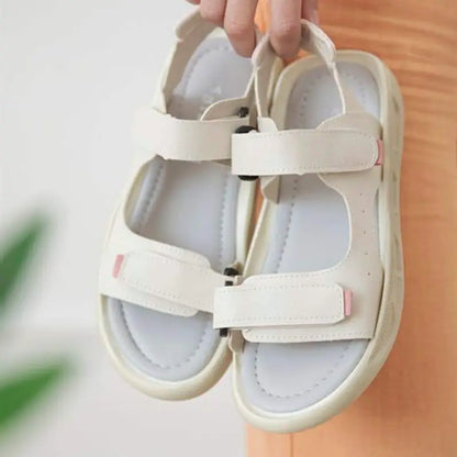 White sandals with velcro straps and a cushioned sole.