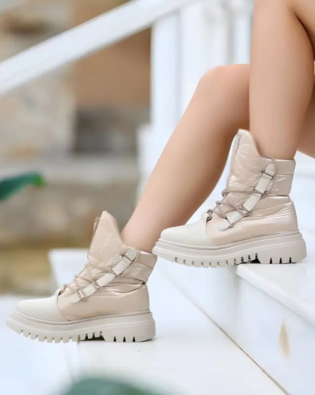 Beige combat boots with chunky treaded soles and lace-up design.