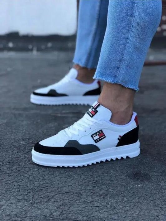 White and black athletic sneakers with a chunky sole and red logo patch.