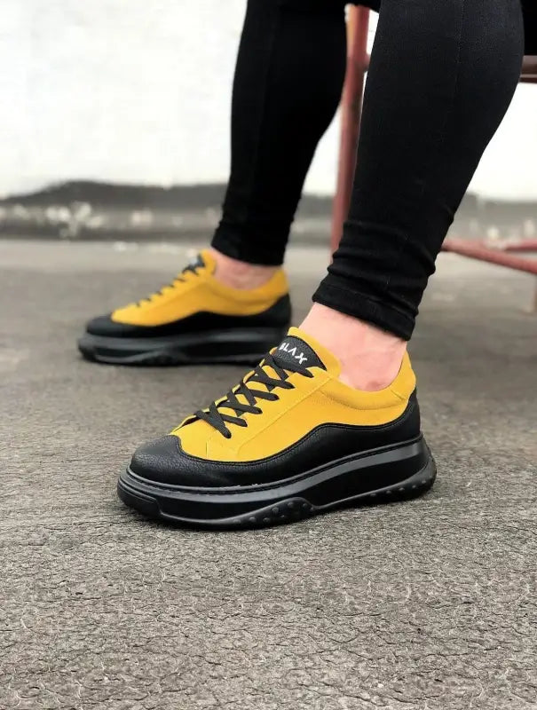 Yellow and black chunky sneakers with a thick platform sole and black laces.