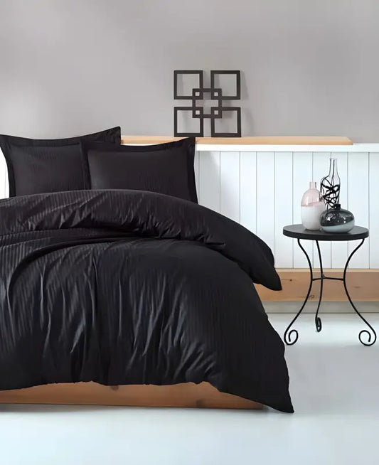 Black duvet cover with matching pillowcases on a bed.