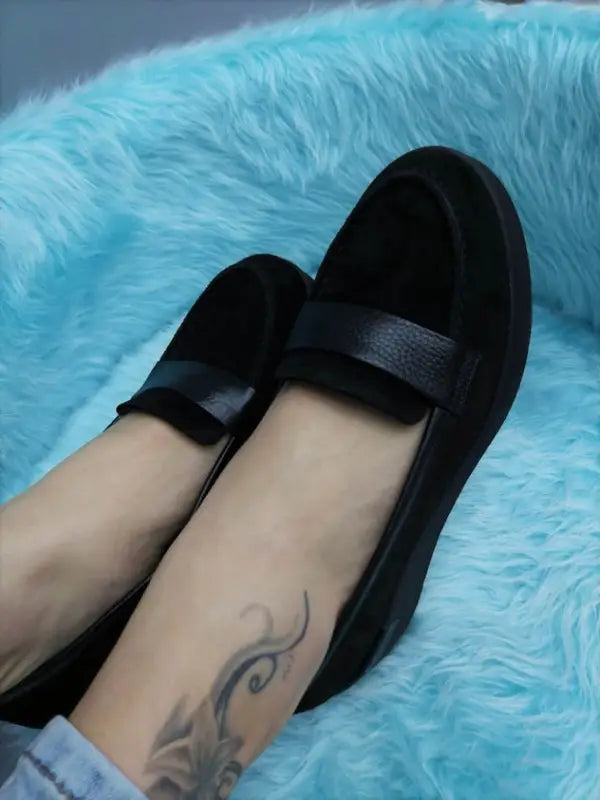 Black suede loafers with a leather strap across the top.