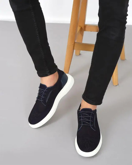 Black suede sneakers with white soles and dark laces.