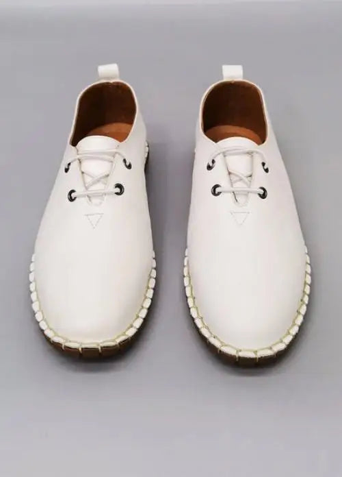 White leather lace-up espadrille shoes with stitched soles.