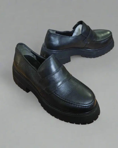 Black leather loafers with chunky rubber soles.