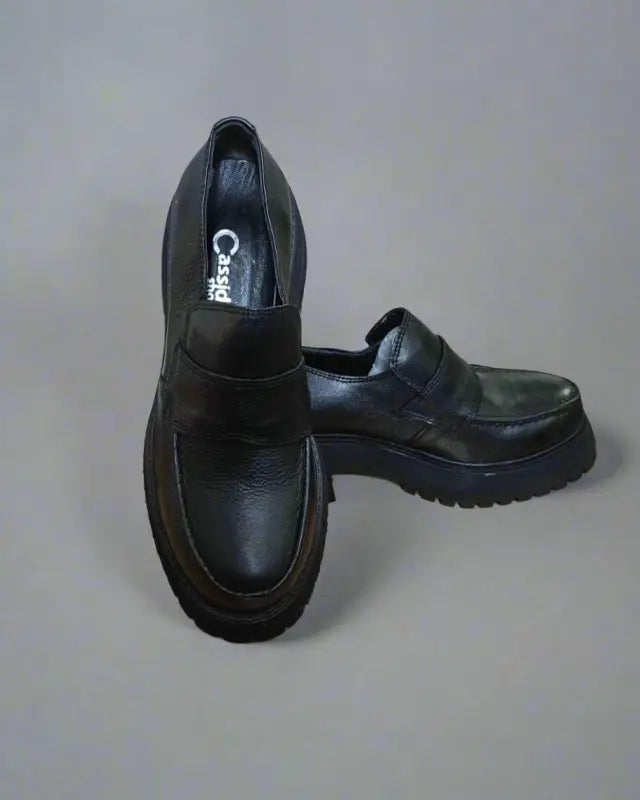 Black leather platform loafers with chunky soles.