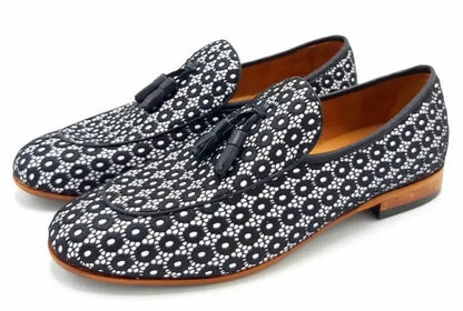 Floral patterned loafers with black tassels and brown leather soles.