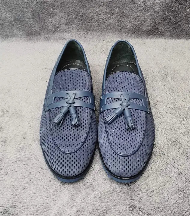 Pair of grey textured loafers with decorative tassels.