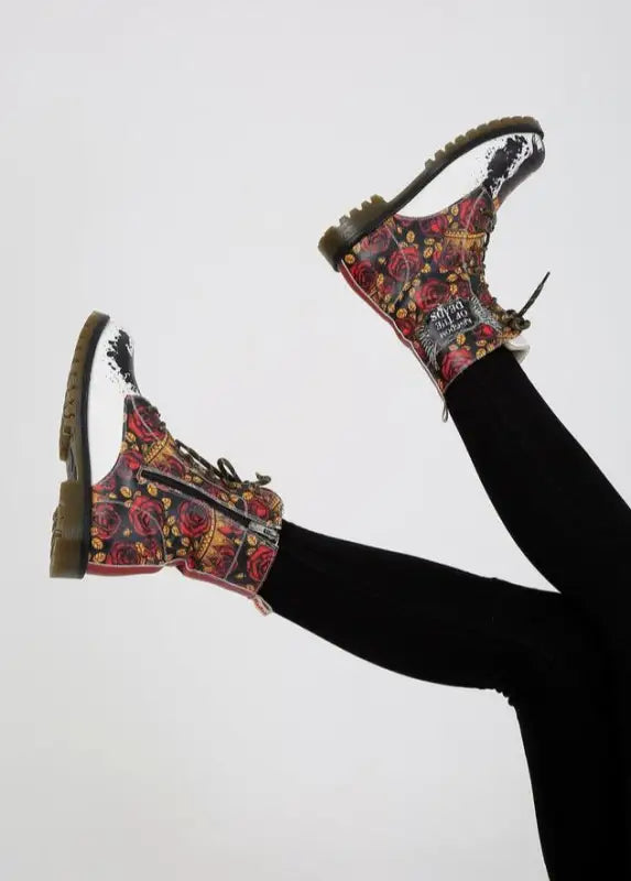 Floral print combat boots with black laces worn with dark leggings.