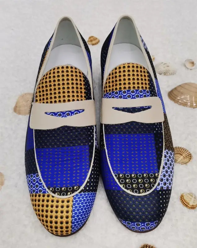 Patterned loafers featuring blue, black, and gold geometric designs with white straps across the top.