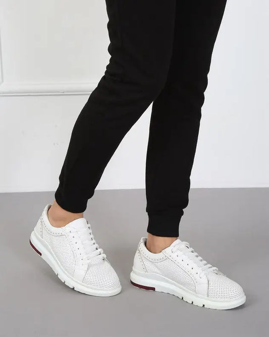 White perforated leather sneakers with laces and a sporty sole design.