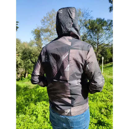 Black hooded jacket with geometric pattern designs worn by someone facing away from the camera.