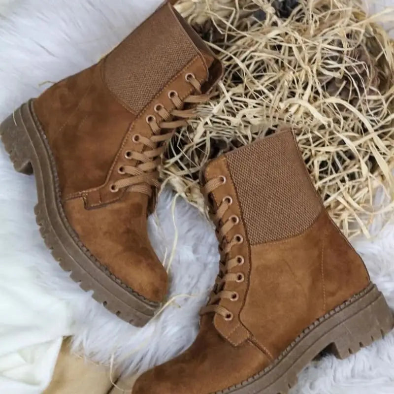 Brown leather combat boots with lace-up fronts and textured soles.