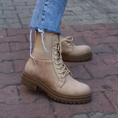 Beige leather combat boot with thick treaded sole and laces.