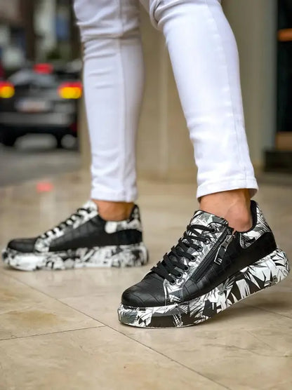 Black and white sneakers with a marbled pattern on the sole and white pants above them.