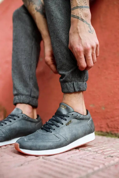 Gray suede sneakers with white soles and dark laces.