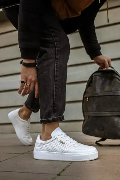 White perforated leather sneakers with a platform sole.