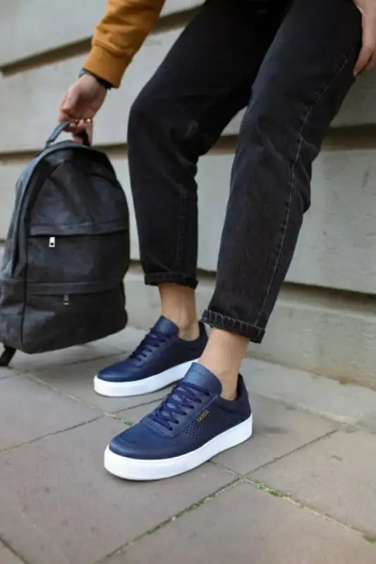 Navy blue sneakers with white soles and laces.