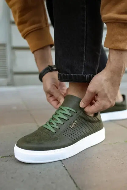 Green leather sneaker with white sole and perforated details.