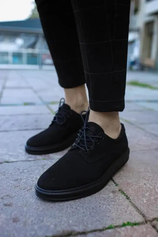 Black suede oxford shoes with laces.