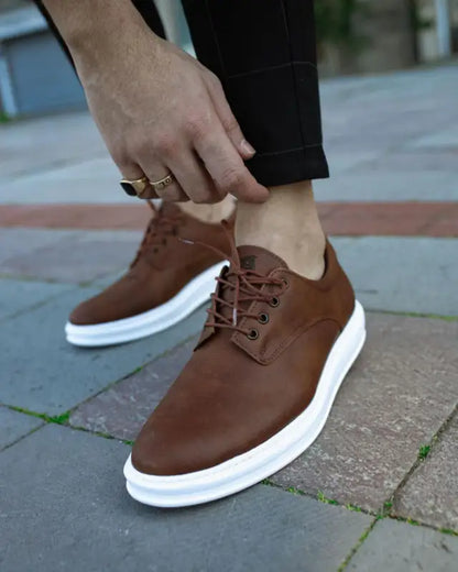 Brown leather sneakers with white soles and laces.