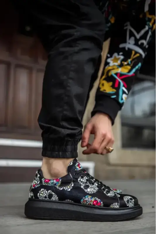 Black platform sneaker with floral skull pattern design.