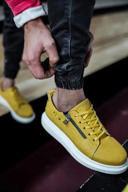 Bright yellow sneaker with white sole and black zipper detail.