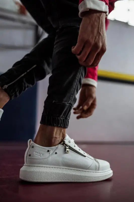 White Alexander McQueen sneaker with a thick sole and silver studs.