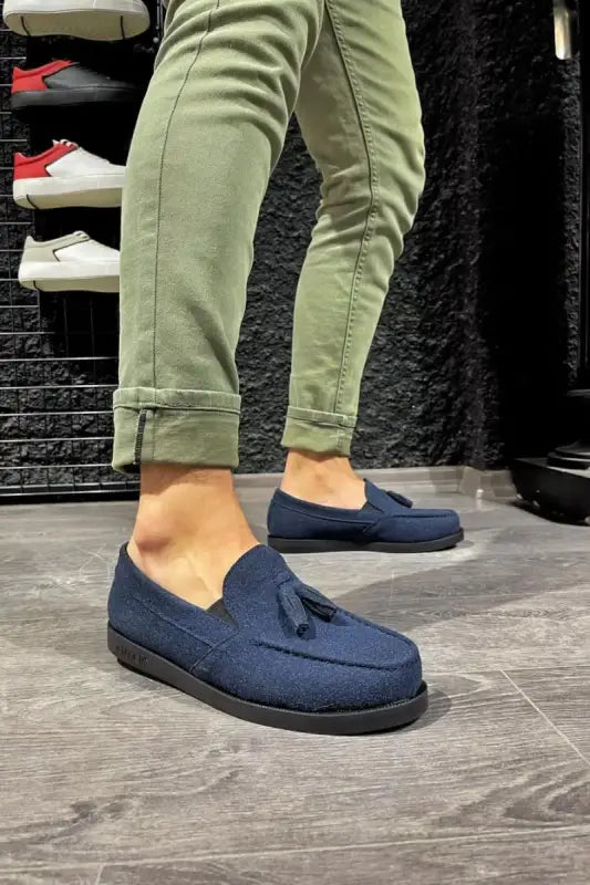 Navy blue suede loafers with tassels worn with olive green pants.