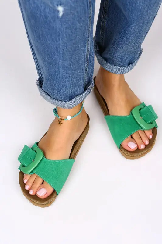 Green bow-adorned slide sandals with a cork-style footbed.