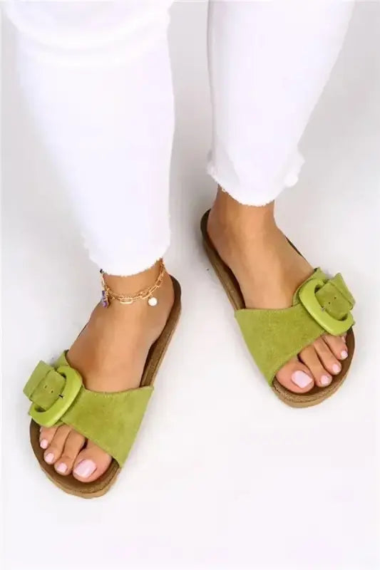 Lime green sandals with floral decorations and a delicate gold ankle chain.